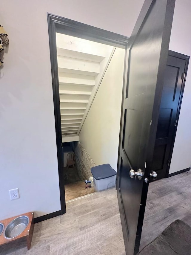 staircase featuring baseboards and wood finished floors