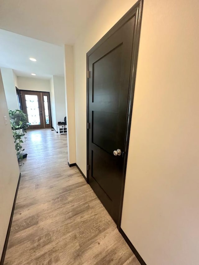 hallway with light wood-style flooring and baseboards