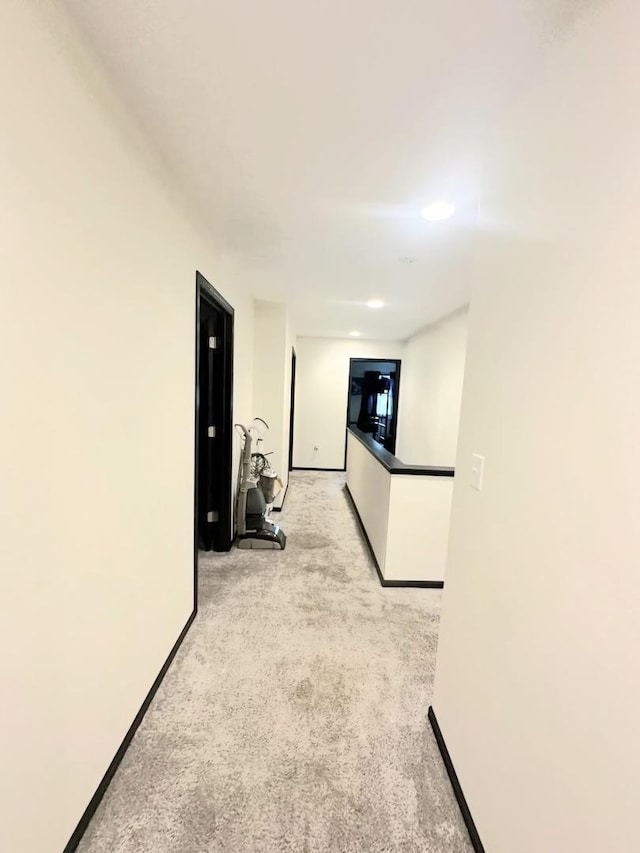 corridor with light carpet and baseboards