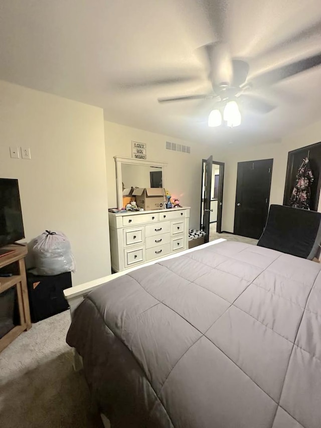 bedroom with carpet floors, visible vents, and a ceiling fan