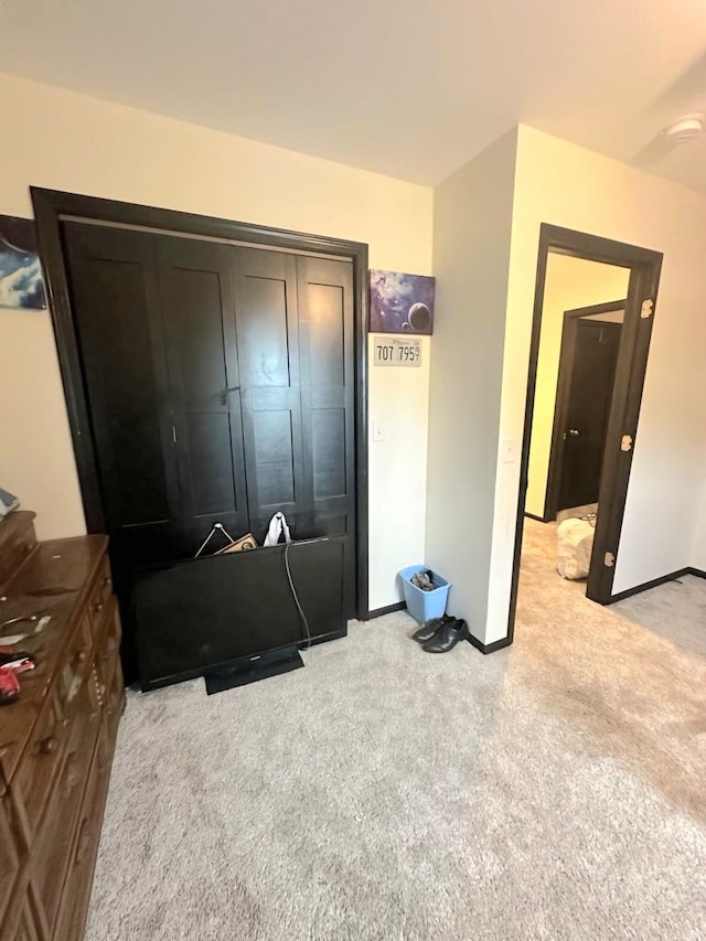 bedroom with light carpet and baseboards