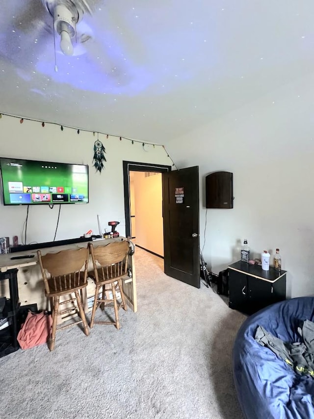 carpeted dining space with vaulted ceiling