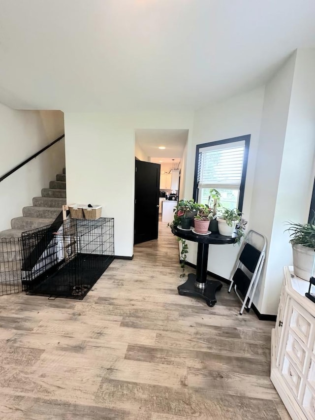 interior space featuring stairs, light wood finished floors, and baseboards