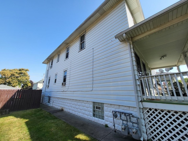 view of home's exterior featuring fence and a lawn