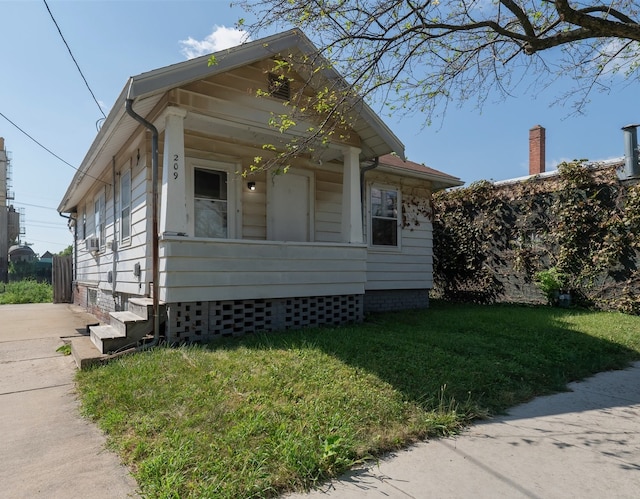 bungalow-style home with covered porch and a front yard