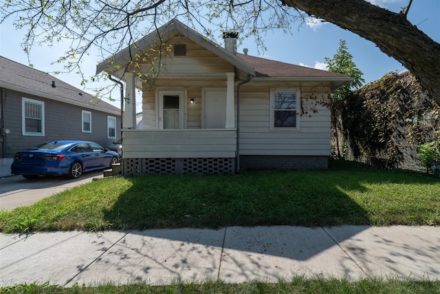 bungalow-style house featuring a front lawn