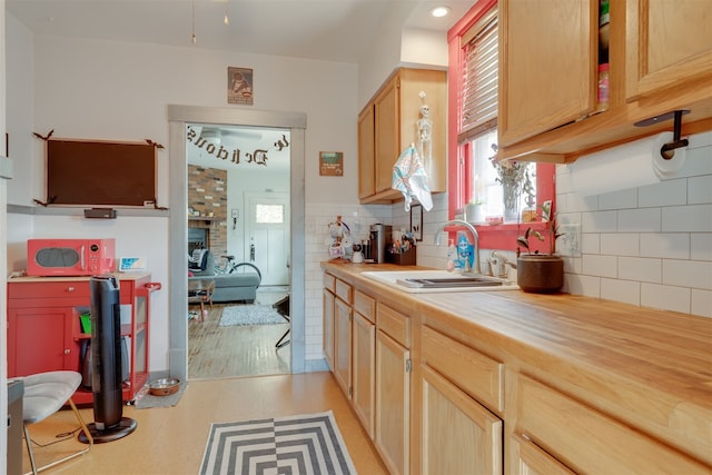 kitchen featuring light brown cabinets, light hardwood / wood-style floors, tasteful backsplash, and sink