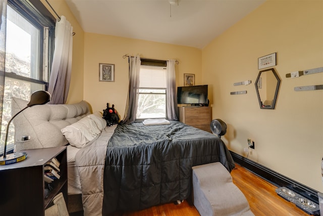 bedroom with vaulted ceiling and wood-type flooring