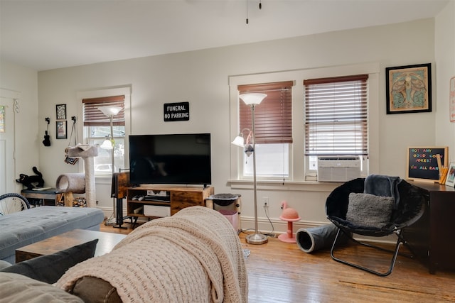 living room with cooling unit, plenty of natural light, and hardwood / wood-style floors