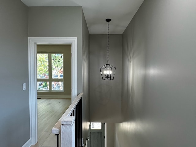 stairs with a notable chandelier and wood-type flooring