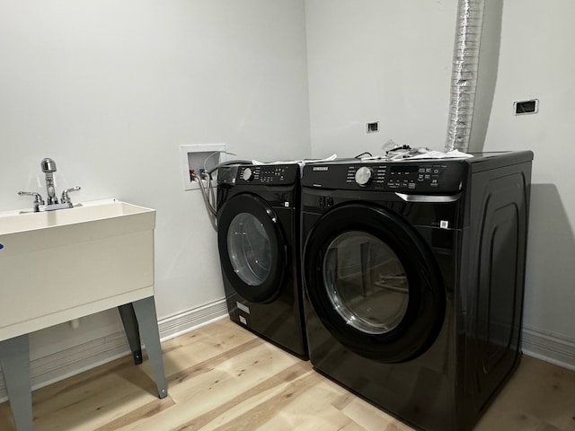 washroom featuring light wood-type flooring and washing machine and clothes dryer