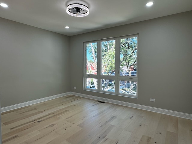 spare room with a healthy amount of sunlight, ceiling fan, and light wood-type flooring