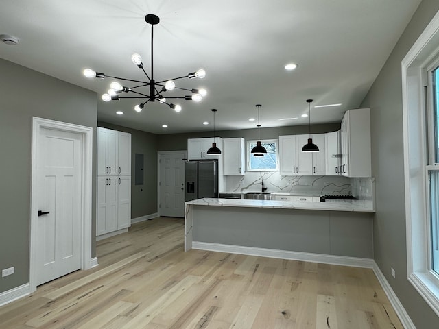 kitchen with stainless steel fridge with ice dispenser, white cabinetry, kitchen peninsula, and light hardwood / wood-style floors