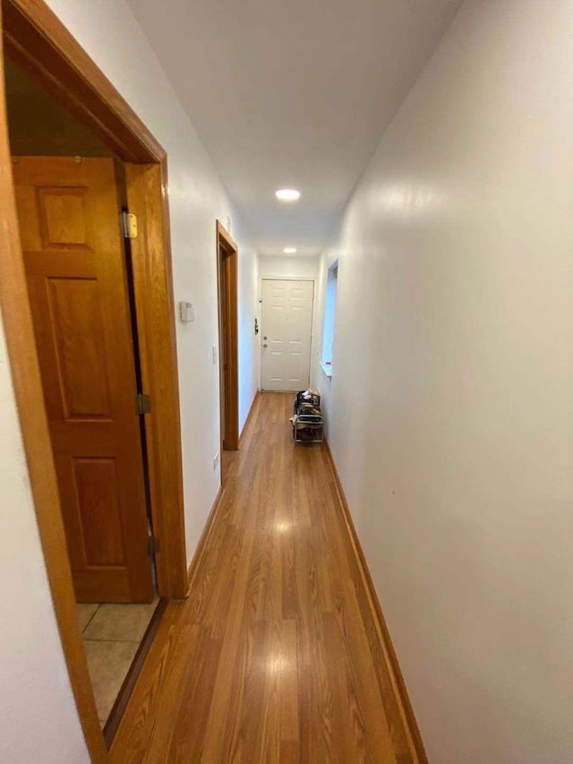 corridor with light hardwood / wood-style floors