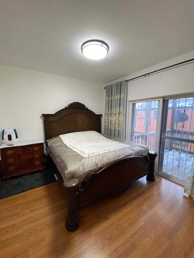 bedroom featuring access to exterior and hardwood / wood-style floors