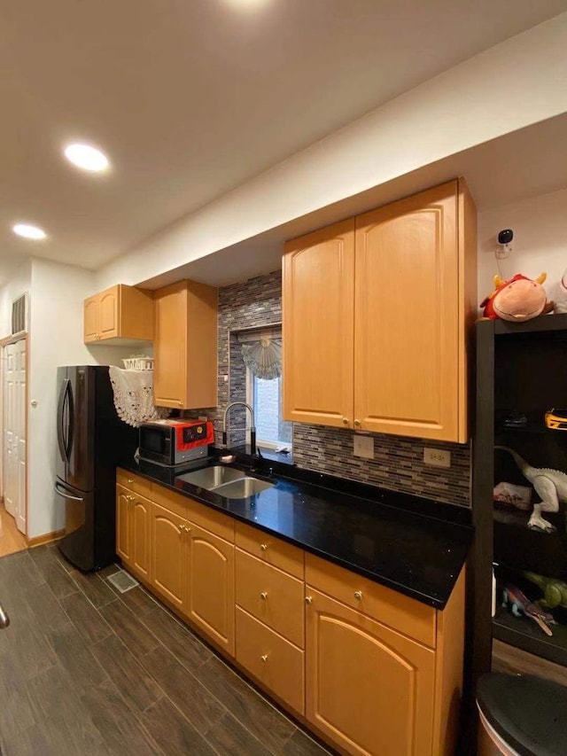 kitchen with stainless steel appliances, sink, light brown cabinets, dark wood-type flooring, and tasteful backsplash