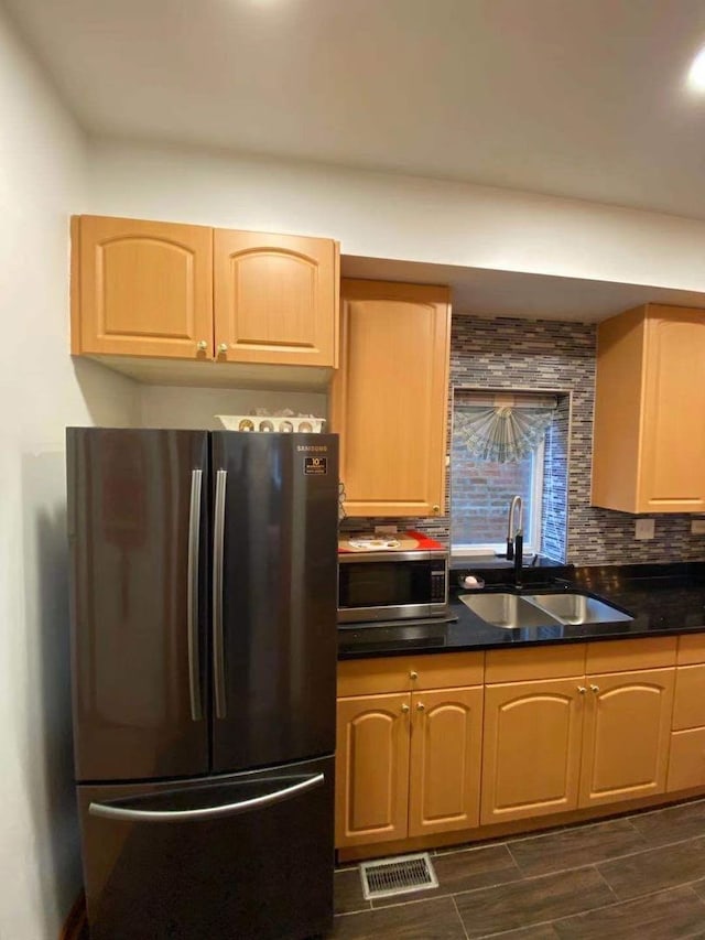 kitchen with appliances with stainless steel finishes, light brown cabinets, dark hardwood / wood-style floors, and sink