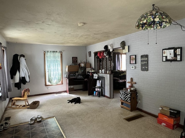 interior space featuring a textured ceiling, plenty of natural light, carpet flooring, and visible vents