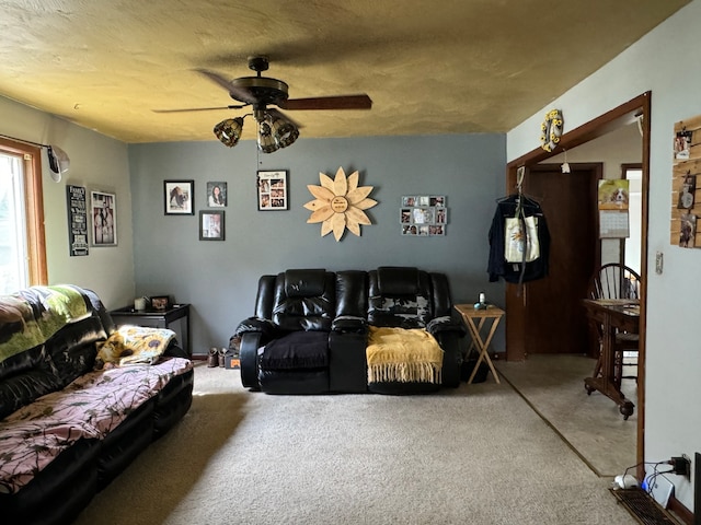 living room with a textured ceiling, carpet flooring, and ceiling fan