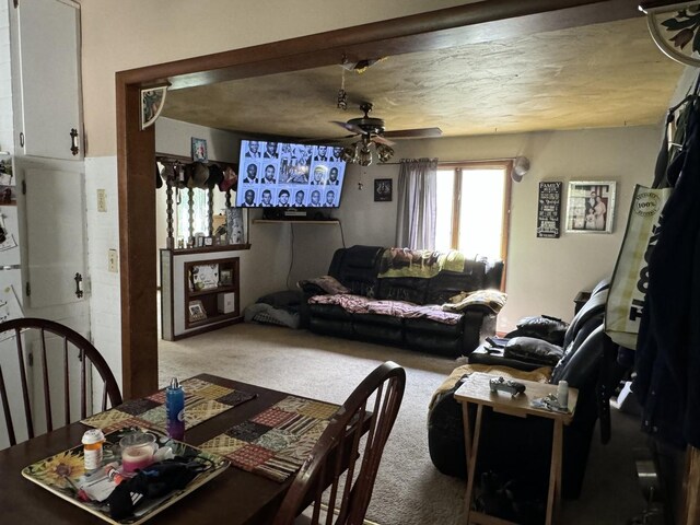 carpeted living room featuring a textured ceiling and ceiling fan