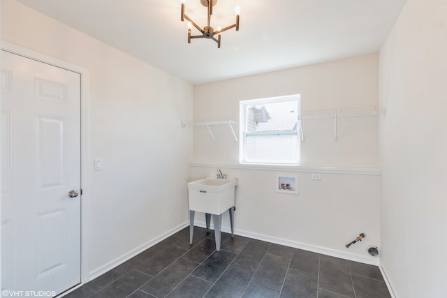 washroom with hookup for a gas dryer, a chandelier, hookup for a washing machine, and dark tile patterned flooring