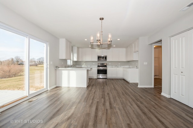 kitchen with white cabinetry, a healthy amount of sunlight, appliances with stainless steel finishes, and dark hardwood / wood-style floors