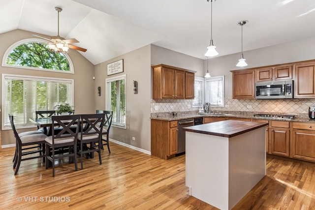 kitchen featuring a center island, ceiling fan, light wood-type flooring, and appliances with stainless steel finishes