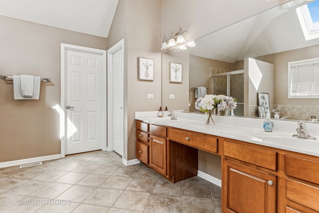 bathroom with a shower with door, vanity, tile patterned floors, and lofted ceiling with skylight