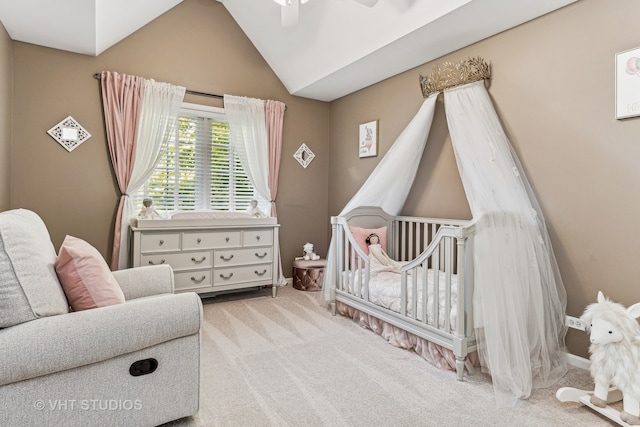 bedroom featuring light colored carpet, vaulted ceiling, a nursery area, and ceiling fan