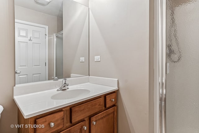 bathroom featuring vanity and a shower with shower door