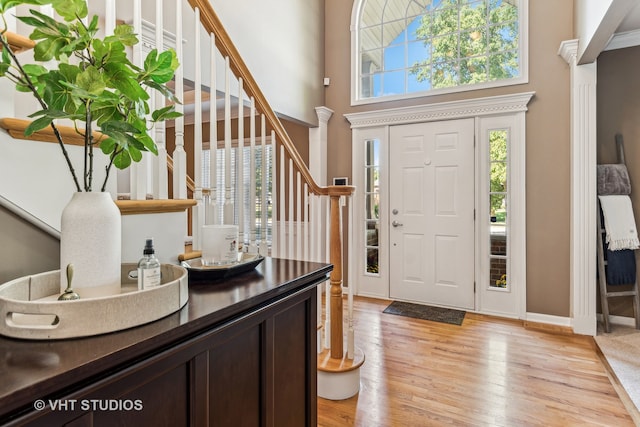 entryway featuring light hardwood / wood-style floors and a towering ceiling