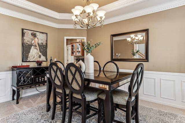 carpeted dining space featuring an inviting chandelier and ornamental molding