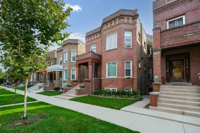 townhome / multi-family property featuring cooling unit and a front yard