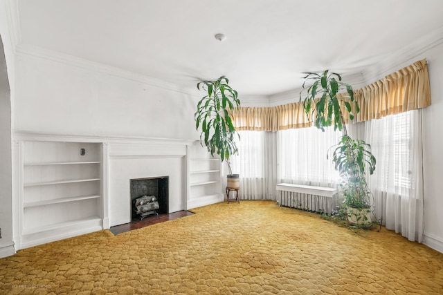 unfurnished living room featuring built in features, carpet flooring, radiator heating unit, and ornamental molding