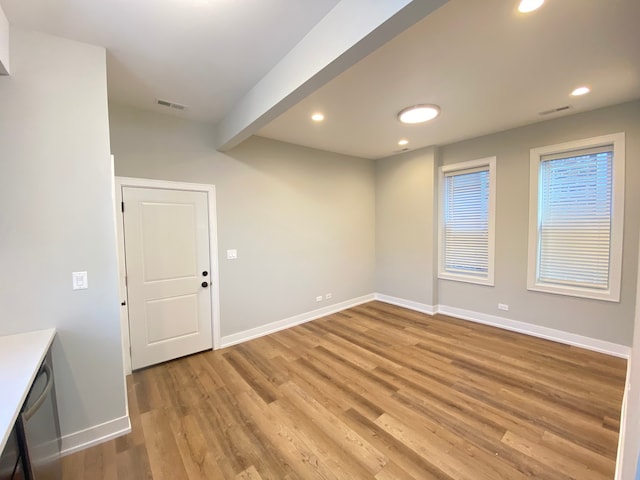 unfurnished room featuring hardwood / wood-style flooring and beam ceiling