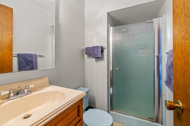 bathroom with vanity, toilet, and an enclosed shower