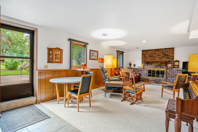 living room with plenty of natural light, a brick fireplace, and light colored carpet