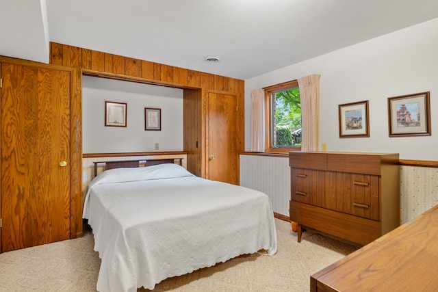 carpeted bedroom with wood walls