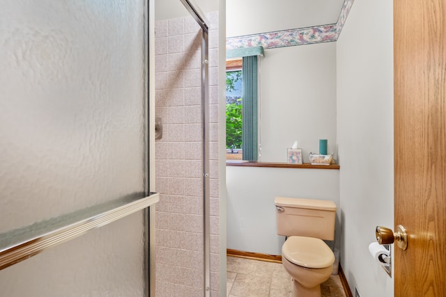 bathroom featuring tile patterned floors, toilet, and a shower with shower door