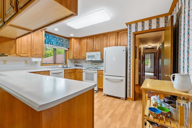 kitchen with white appliances, light hardwood / wood-style floors, and kitchen peninsula