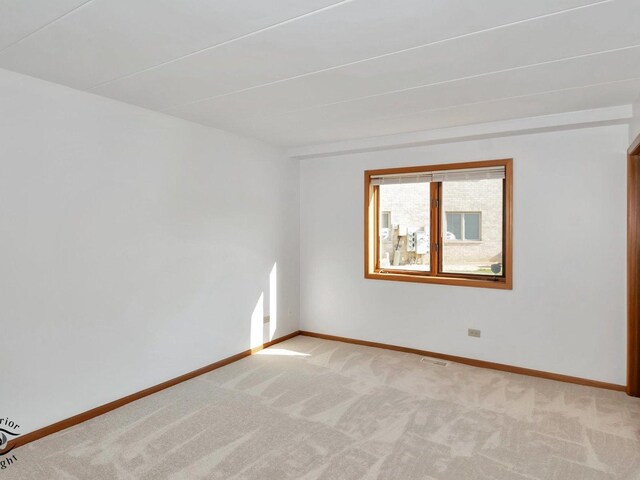 spare room featuring light colored carpet