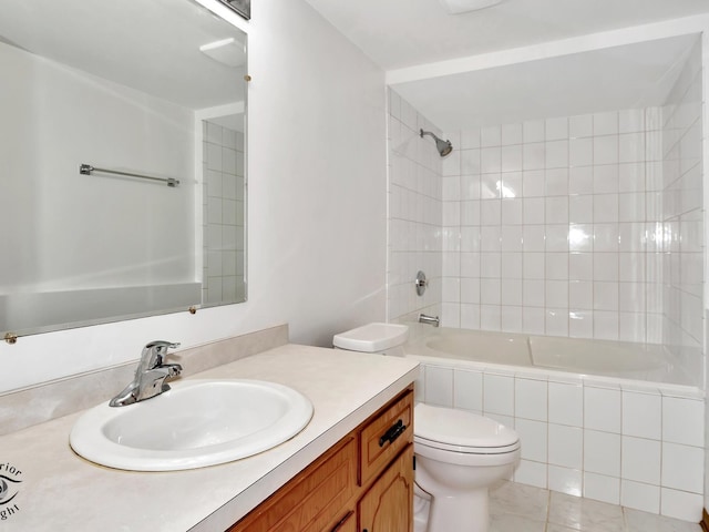 full bathroom featuring tiled shower / bath, vanity, toilet, and tile patterned floors