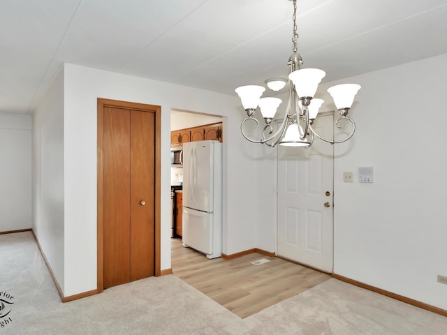 interior space with light wood-type flooring and a notable chandelier