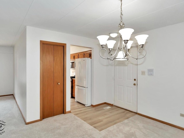 dining space with light carpet, an inviting chandelier, and baseboards