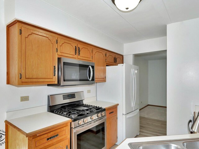 kitchen with hardwood / wood-style floors and stainless steel appliances