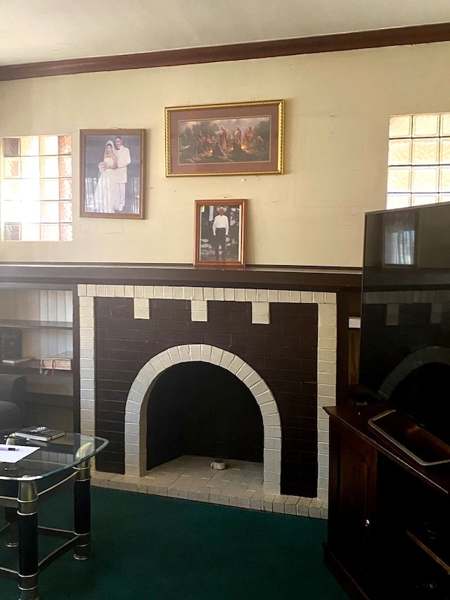 living room featuring ornamental molding and a brick fireplace