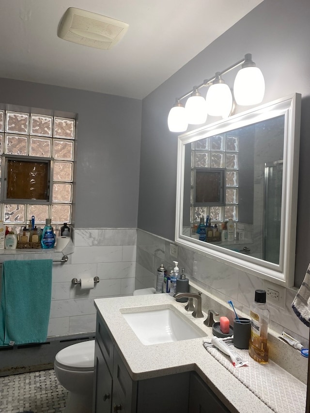 bathroom with vanity, toilet, tile patterned flooring, and a shower with door