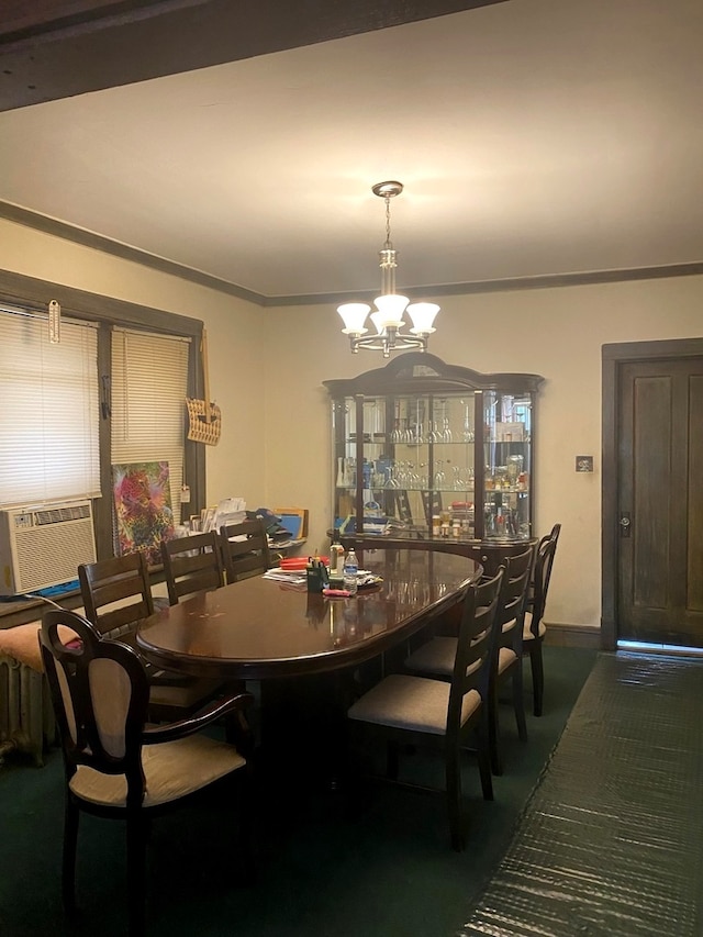 dining area with dark carpet, a notable chandelier, cooling unit, and ornamental molding