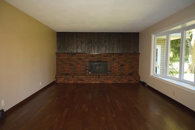 unfurnished living room featuring dark wood-style floors and baseboards