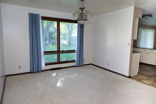 unfurnished room with carpet flooring, a notable chandelier, plenty of natural light, and baseboards